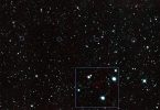 A rugged asteroid drifts against a dense field of bright stars in deep space.